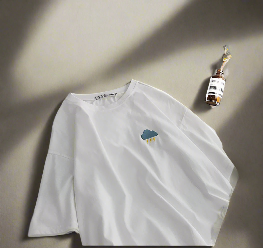 White long-sleeve shirt with a cloud design on a white surface