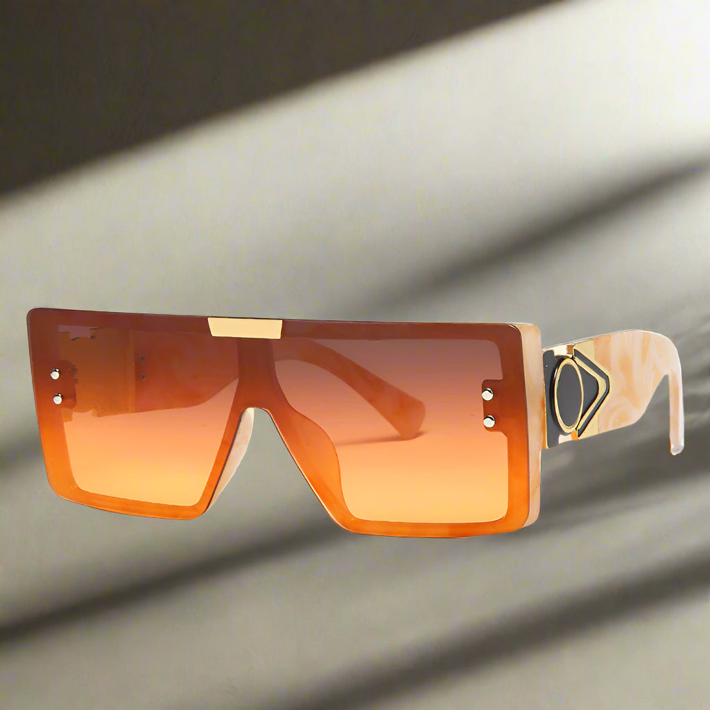 Sunglasses with orange lenses and a unique frame design on a white background