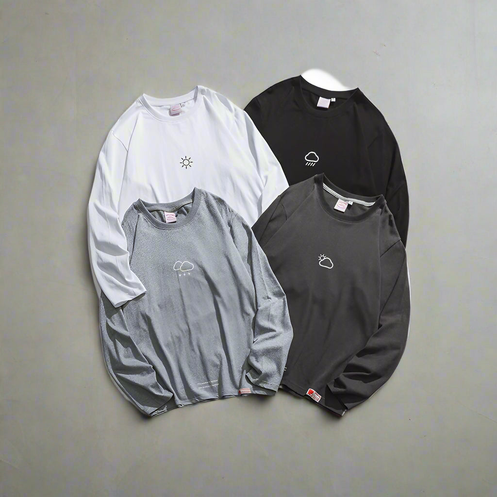Four long-sleeve shirts in different colors with small logos on a white background