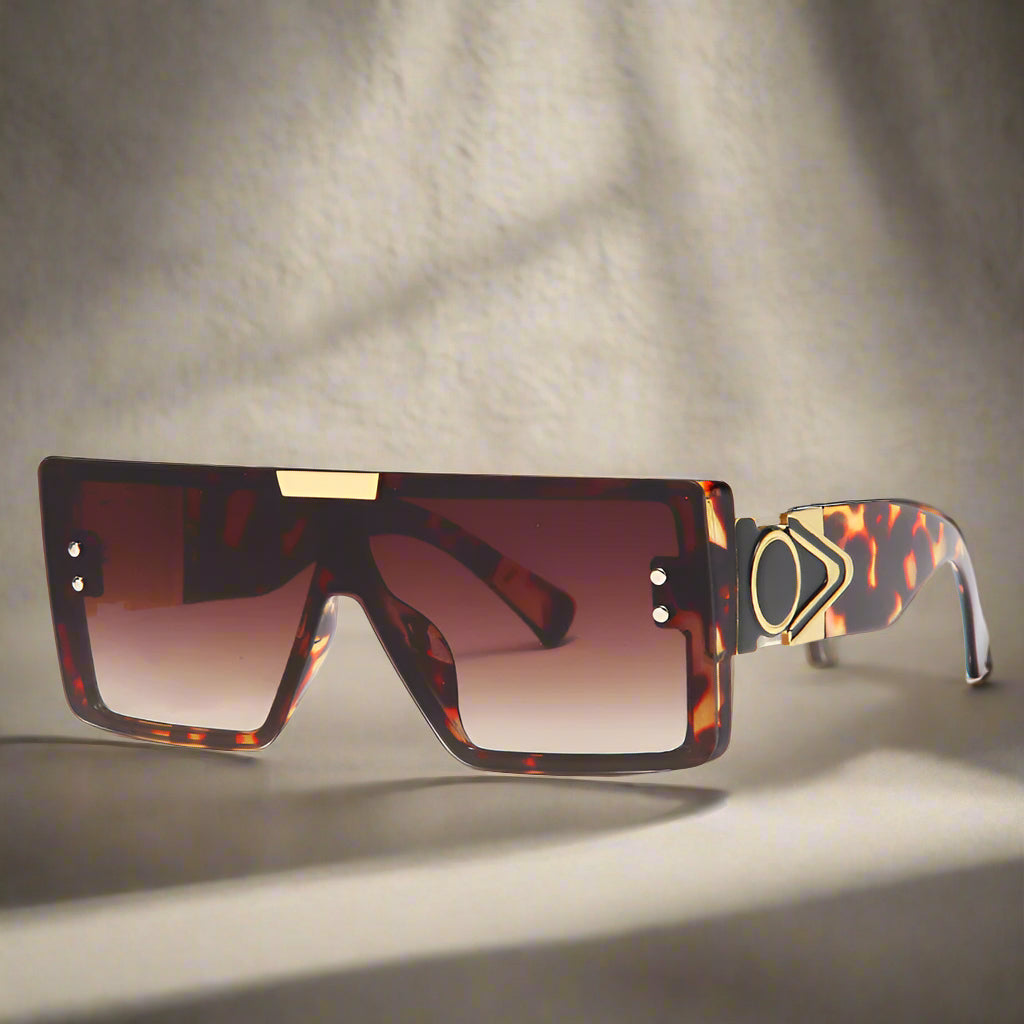 Sunglasses with tortoiseshell frame and brown gradient lenses on a white background